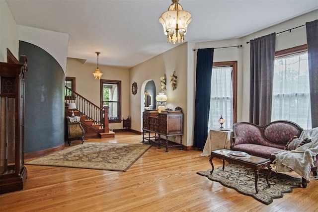 3715 N Mckinley Ave, Oklahoma City, OK 73118 - sitting room featuring arched walkways, wood finished floors, a chandelier, baseboards, and stairway