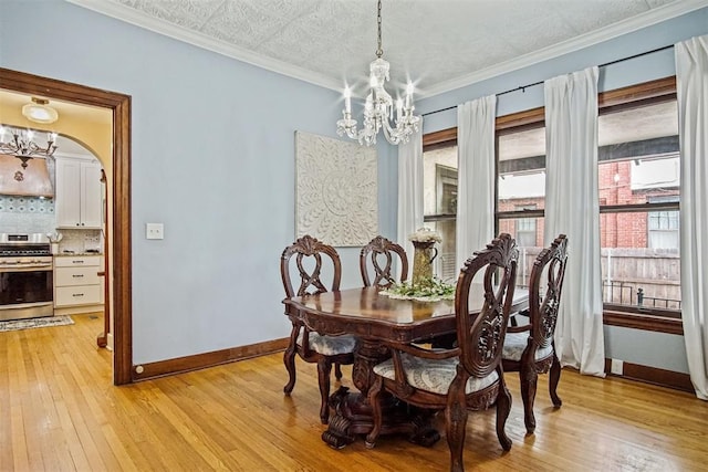3715 N Mckinley Ave, Oklahoma City, OK 73118 - dining area with a chandelier, light wood-type flooring, baseboards, arched walkways, and crown molding