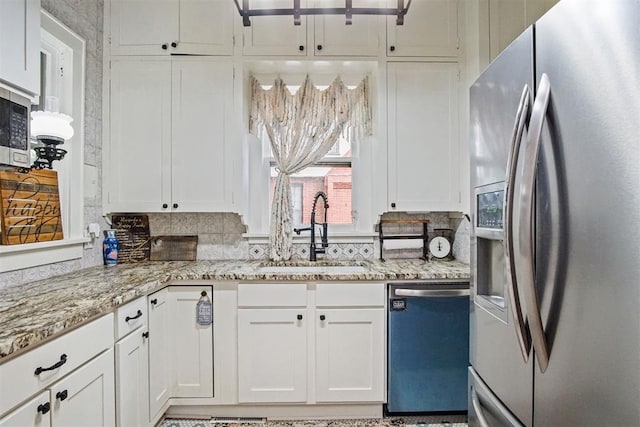3715 N Mckinley Ave, Oklahoma City, OK 73118 - kitchen featuring appliances with stainless steel finishes, a sink, white cabinetry, and backsplash