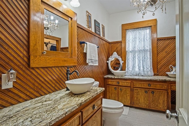3715 N Mckinley Ave, Oklahoma City, OK 73118 - bathroom with a chandelier, vanity, wood walls, a wainscoted wall, and toilet