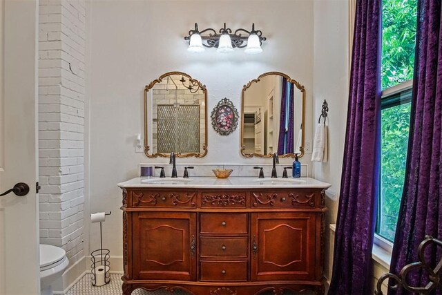 3715 N Mckinley Ave, Oklahoma City, OK 73118 - bathroom with double vanity, toilet, baseboards, and tile patterned flooring