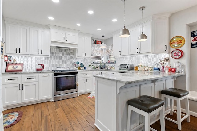 8309 NW 101st St, Oklahoma City, OK 73162 - kitchen with stainless steel electric stove, white cabinets, a peninsula, and recessed lighting