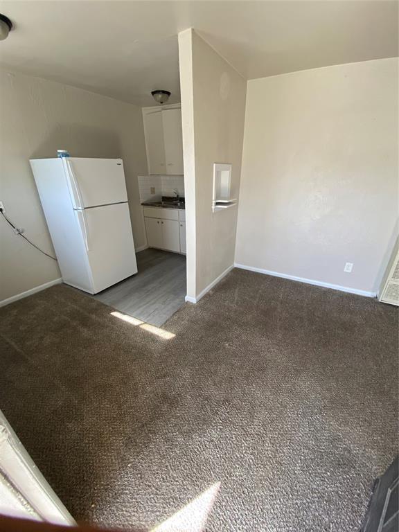2819 SW 33rd St, Oklahoma City, OK 73119 - unfurnished living room with carpet flooring and baseboards