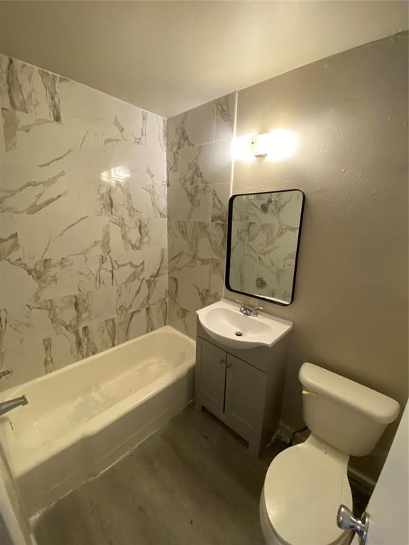 2819 SW 33rd St, Oklahoma City, OK 73119 - bathroom featuring toilet, vanity, wood finished floors, and shower / tub combination