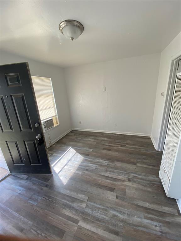 2819 SW 33rd St, Oklahoma City, OK 73119 - unfurnished bedroom featuring a heating unit, dark wood finished floors, baseboards, and cooling unit