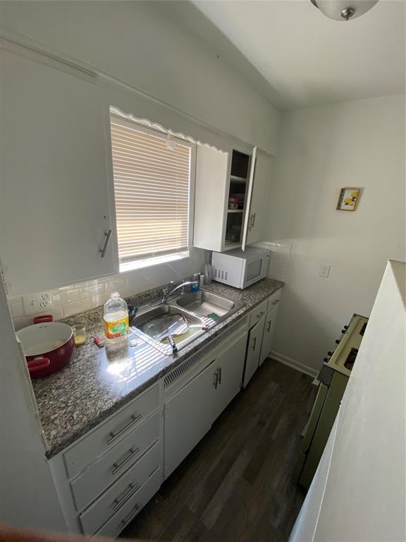 2819 SW 33rd St, Oklahoma City, OK 73119 - kitchen featuring white microwave, dark wood-style floors, and white cabinets