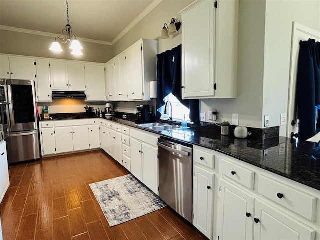 416 S Harrison Ave, Blanchard, OK 73010 - kitchen with stainless steel appliances, a sink, under cabinet range hood, ornamental molding, and white cabinetry