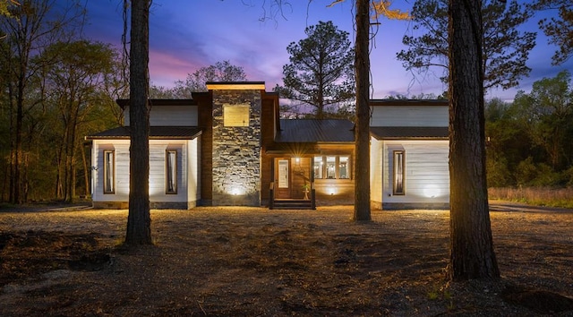 contemporary house with metal roof and stone siding