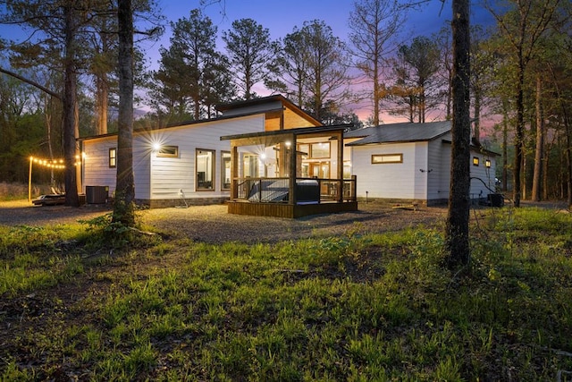 rear view of property with a deck, central AC, and an outdoor structure