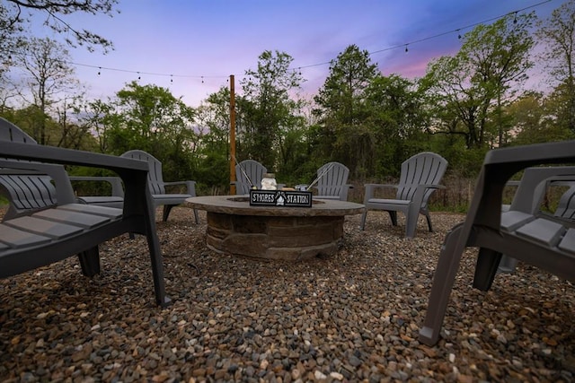 yard at dusk featuring a fire pit