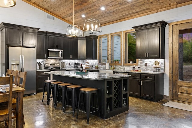 kitchen with stainless steel appliances, wooden ceiling, a center island, a sink, and stone countertops