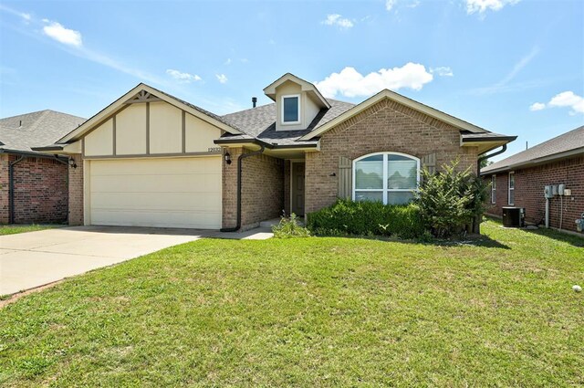 12032 SW 10th St, Yukon, OK 73099 - view of front of property featuring an attached garage, brick siding, a front lawn, driveway, and a shingled roof