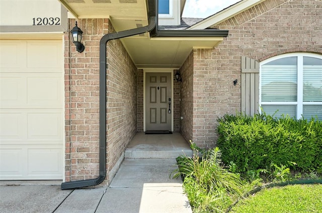 12032 SW 10th St, Yukon, OK 73099 - view of exterior entry featuring brick siding and a garage