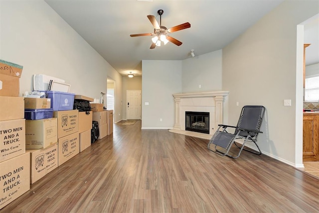 12032 SW 10th St, Yukon, OK 73099 - unfurnished living room with a ceiling fan, a glass covered fireplace, wood finished floors, and plenty of natural light