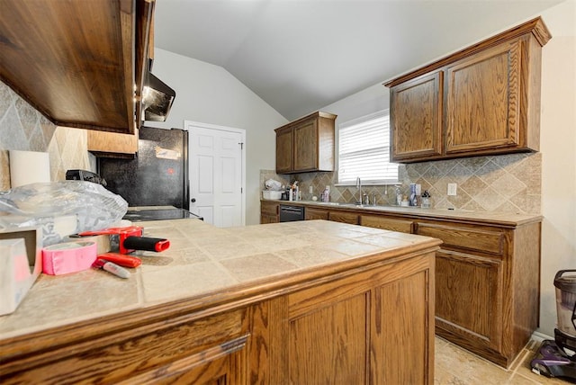 12032 SW 10th St, Yukon, OK 73099 - kitchen with lofted ceiling, tile countertops, tasteful backsplash, black appliances, and wall chimney range hood