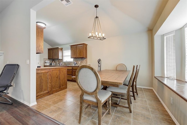 12032 SW 10th St, Yukon, OK 73099 - dining area with vaulted ceiling, a chandelier, and light tile patterned flooring