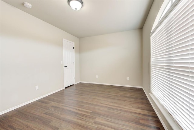 12032 SW 10th St, Yukon, OK 73099 - empty room with a smoke detector, dark wood-style flooring, and plenty of natural light
