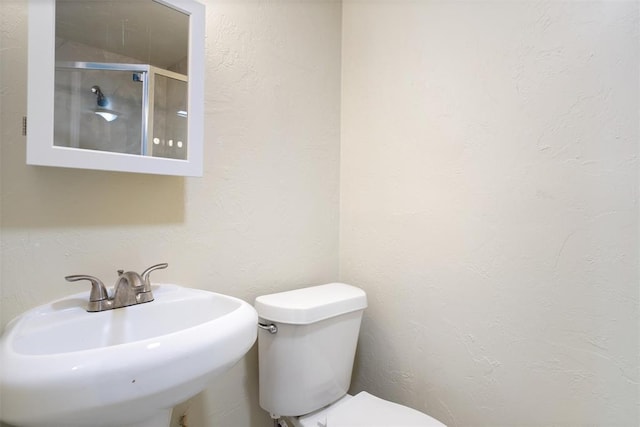 436 SE 54th St, Oklahoma City, OK 73129 - bathroom featuring a sink, toilet, a shower stall, and a textured wall