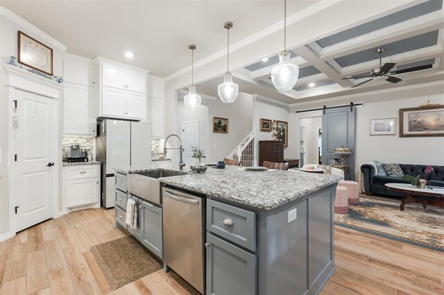 8208 Poplar Dr, Edmond, OK 73034 - kitchen with stainless steel dishwasher, a barn door, a sink, gray cabinetry, and open floor plan