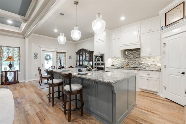 8208 Poplar Dr, Edmond, OK 73034 - kitchen featuring ornamental molding, stainless steel appliances, backsplash, white cabinetry, and light stone counters