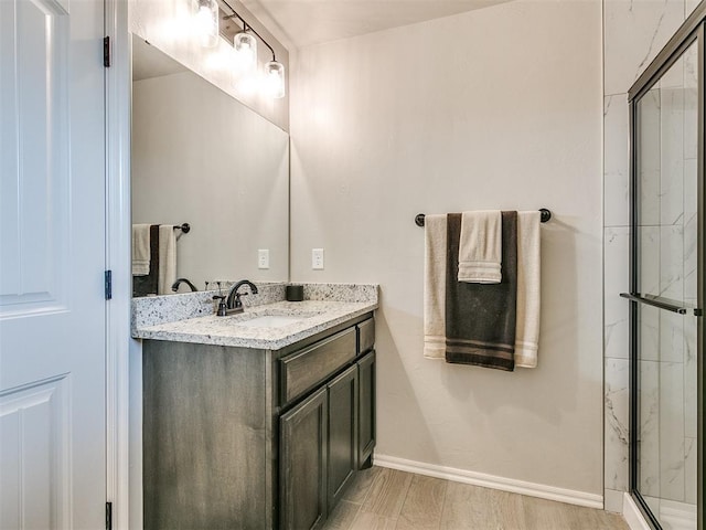 6965 Seabiscuit Ln, Guthrie, OK 73044 - bathroom with vanity, a stall shower, baseboards, and wood finished floors