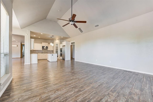 3401 Fox Hill Ter, Edmond, OK 73034 - unfurnished living room featuring a ceiling fan, high vaulted ceiling, and wood finished floors