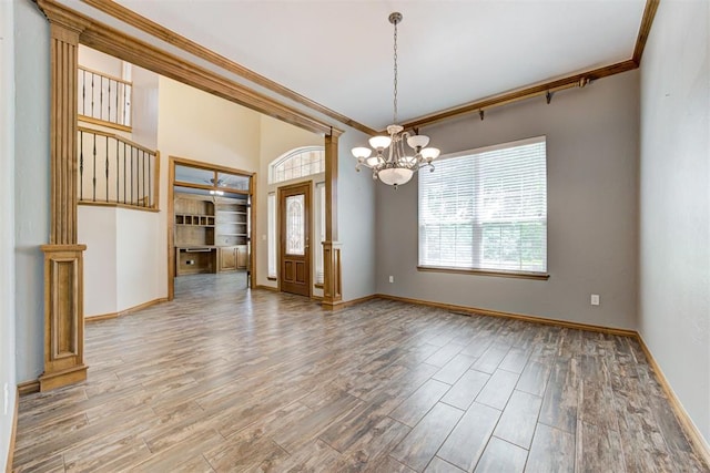 3401 Fox Hill Ter, Edmond, OK 73034 - spare room with crown molding, a chandelier, wood finished floors, and ornate columns