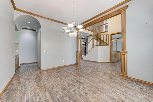 3401 Fox Hill Ter, Edmond, OK 73034 - empty room with wood finished floors, crown molding, stairs, arched walkways, and a chandelier