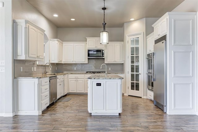 3401 Fox Hill Ter, Edmond, OK 73034 - kitchen featuring appliances with stainless steel finishes, a kitchen island, wood finished floors, white cabinets, and recessed lighting