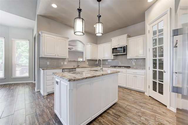 3401 Fox Hill Ter, Edmond, OK 73034 - kitchen featuring appliances with stainless steel finishes, white cabinetry, backsplash, an island with sink, and recessed lighting