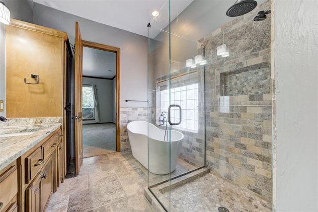 3401 Fox Hill Ter, Edmond, OK 73034 - bathroom with a shower stall, a soaking tub, vanity, stone tile flooring, and tile walls
