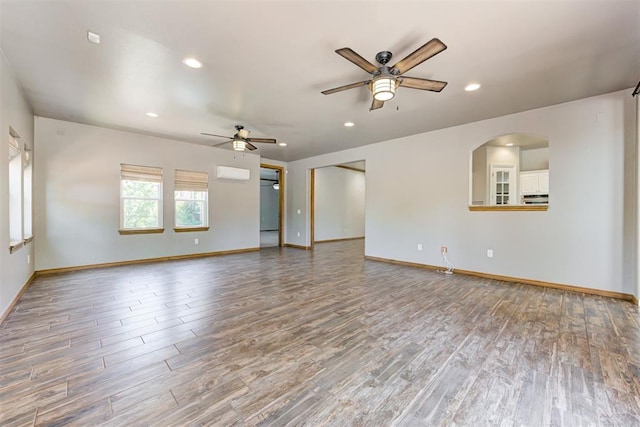3401 Fox Hill Ter, Edmond, OK 73034 - spare room featuring wood finished floors, ceiling fan, recessed lighting, and a wall mounted air conditioner
