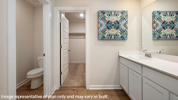 2504 Kathleens Xing, Yukon, OK 73099 - bathroom featuring vanity, toilet, wood finished floors, and baseboards