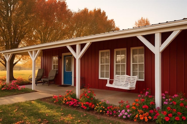 doorway to property with covered porch and board and batten siding