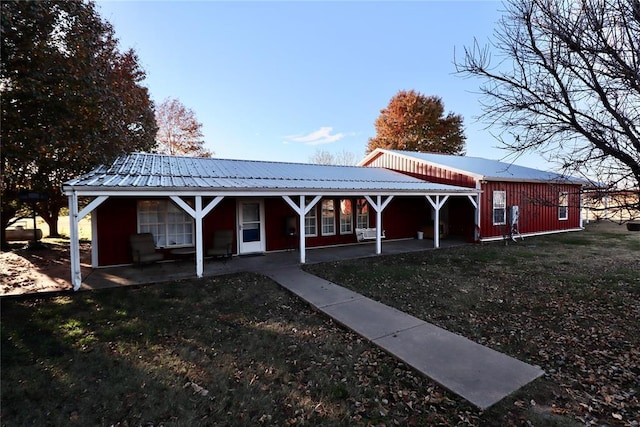 back of property featuring a patio area and metal roof