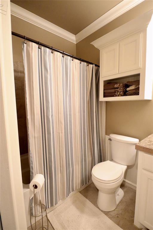 full bathroom with ornamental molding, toilet, vanity, and baseboards