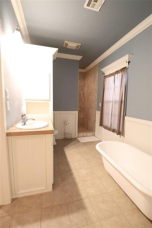 full bathroom with wainscoting, crown molding, a stall shower, vanity, and a soaking tub