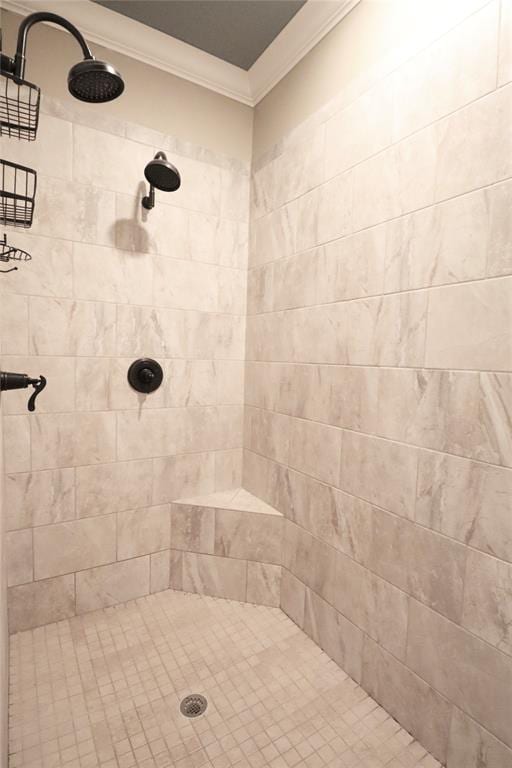 bathroom featuring ornamental molding and tiled shower
