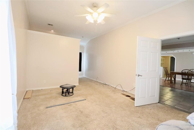 unfurnished living room with ceiling fan, ornamental molding, carpet, and baseboards