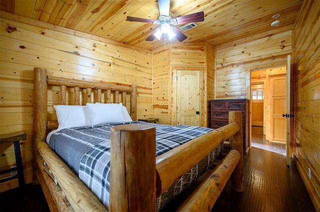 bedroom with wooden walls, wooden ceiling, and dark wood-style flooring