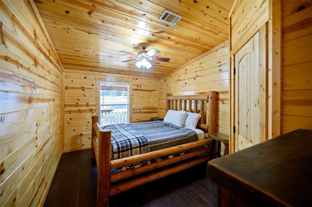 bedroom with vaulted ceiling, wood ceiling, wooden walls, and dark wood-style floors