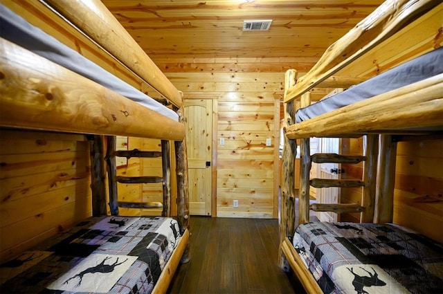 bedroom with wooden walls, dark wood-style flooring, and wooden ceiling