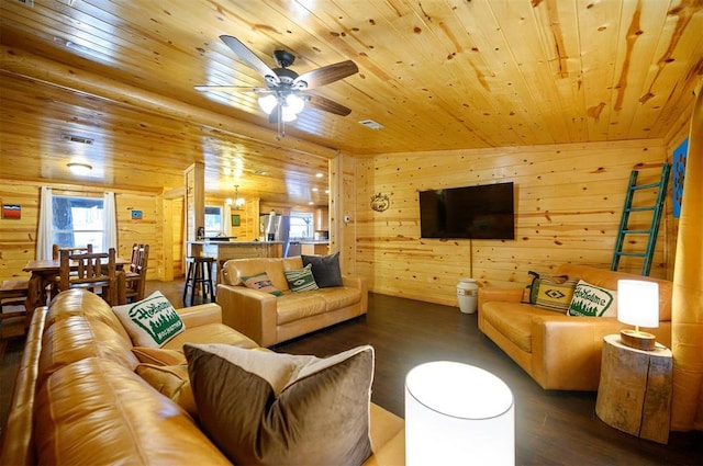 living room with wood finished floors, wood ceiling, ceiling fan, wooden walls, and a chandelier