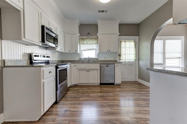100 S Macomb Ave, El Reno, OK 73036 - kitchen featuring appliances with stainless steel finishes, dark wood-type flooring, white cabinets, and a sink