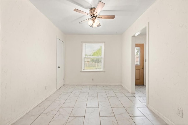 2545 W Eubanks St, Oklahoma City, OK 73112 - empty room featuring light marble finish flooring, ceiling fan, and baseboards