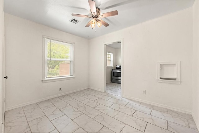 2545 W Eubanks St, Oklahoma City, OK 73112 - empty room featuring light marble finish floors, ceiling fan, and baseboards