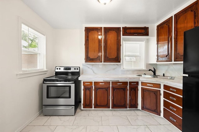 2545 W Eubanks St, Oklahoma City, OK 73112 - kitchen featuring stainless steel electric range oven, a sink, light marble finish floors, freestanding refrigerator, and light countertops