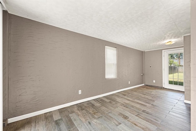 2545 W Eubanks St, Oklahoma City, OK 73112 - spare room with wood finished floors, a textured wall, and baseboards