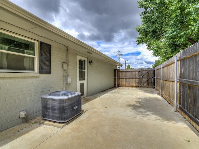 view of patio with central AC and fence