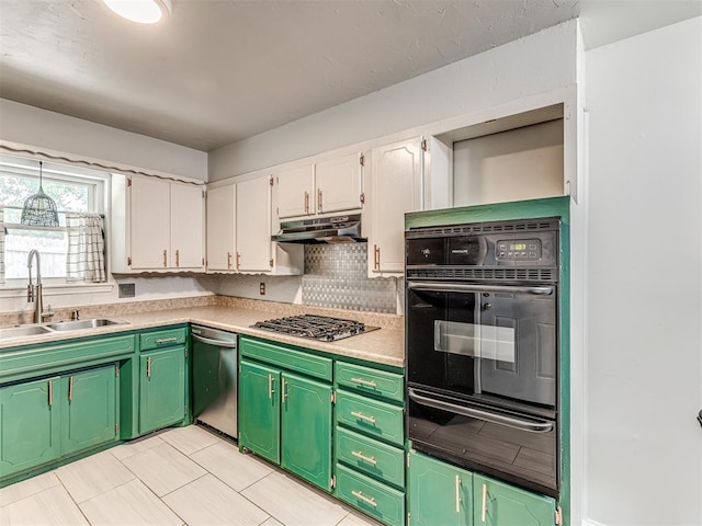kitchen with stainless steel appliances, a warming drawer, a sink, under cabinet range hood, and white cabinetry